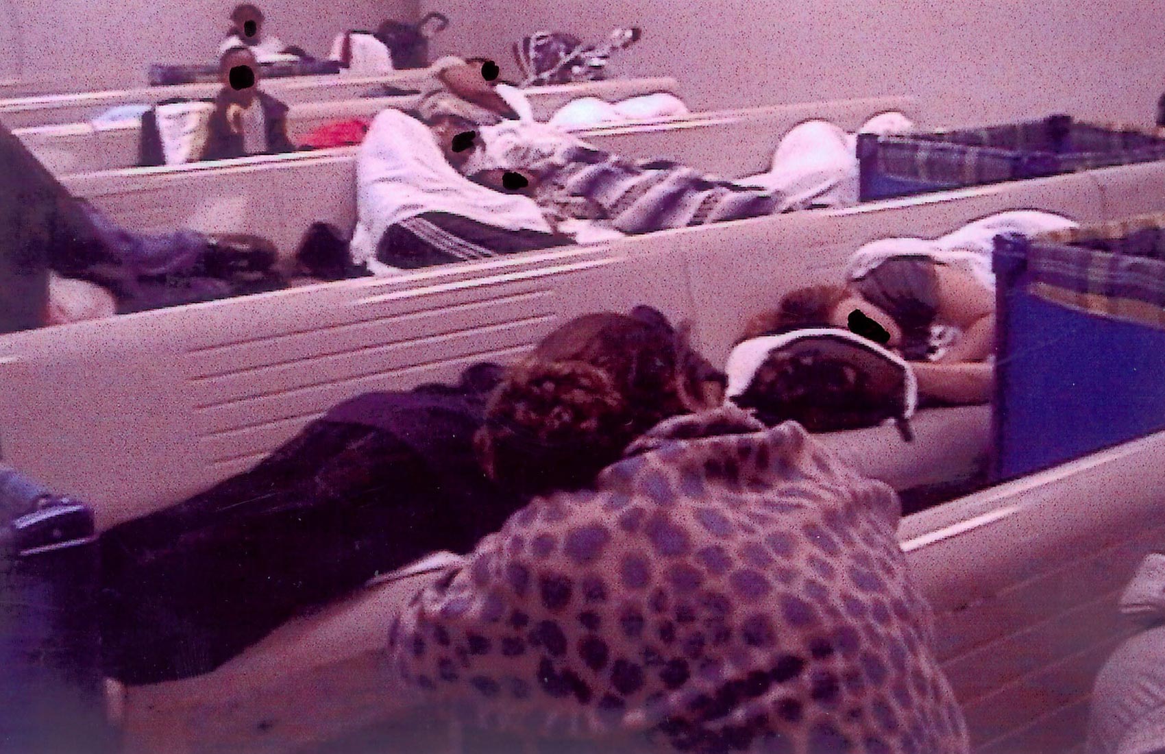 A 대기실의 벤치와 바닥에서 자고 있는 아이들이 있는 노숙자 가족